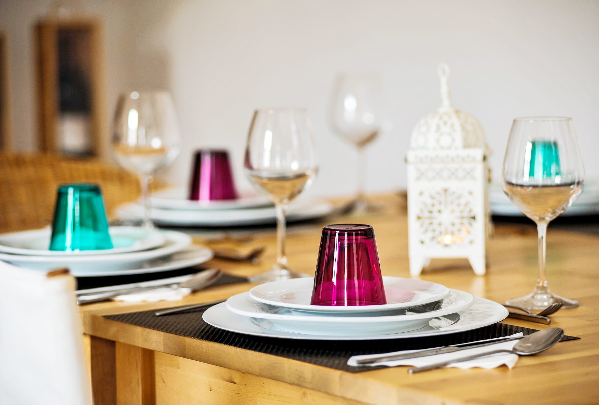 Mesa posta com copos coloridos e ambiente acolhedor